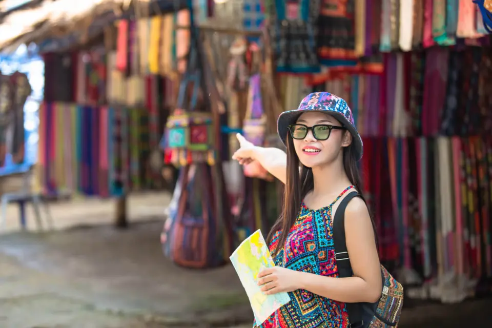 young asian woman points her finger on a Goan market rows